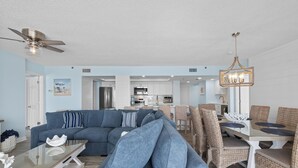 A modern living room with a sectional sofa, dining table, and chairs.