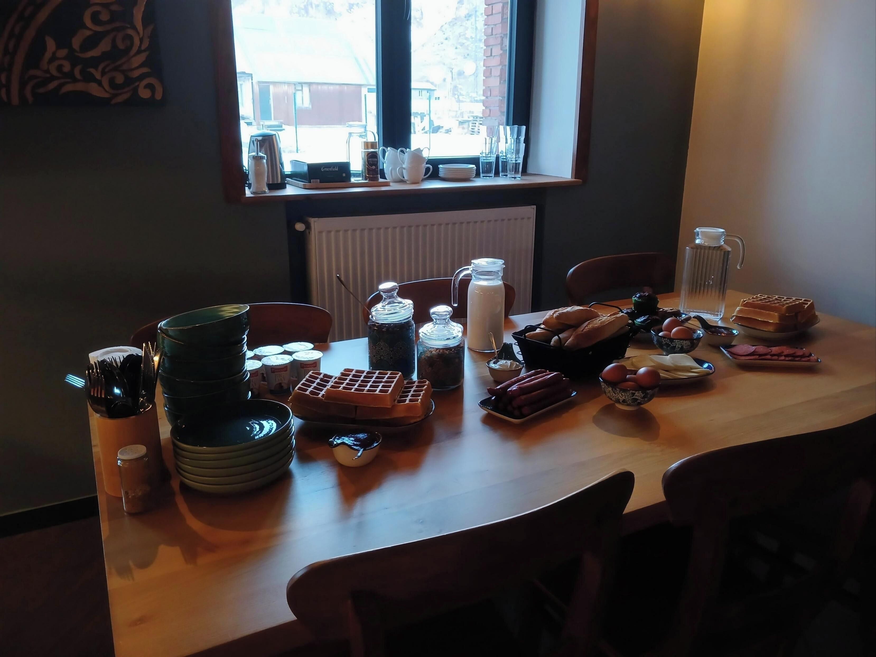 A dining table with various food items, utensils, and condiments.
