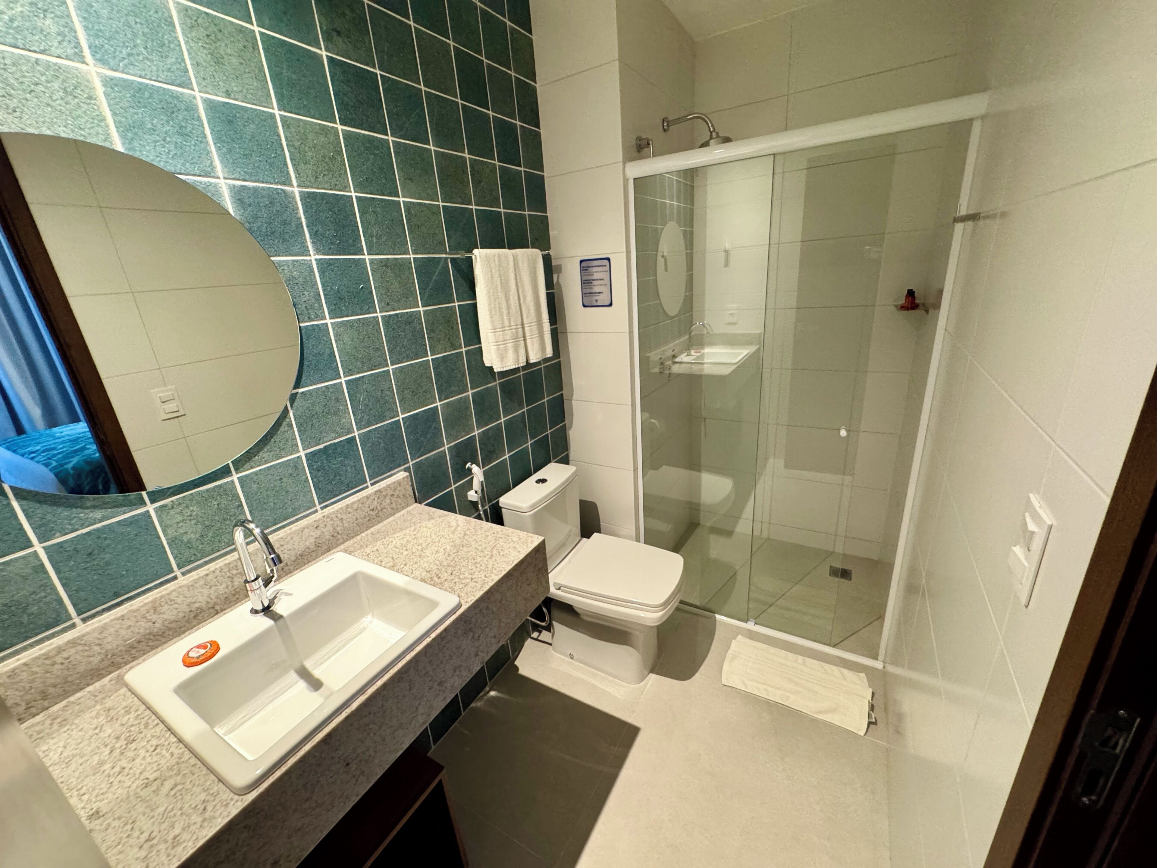 A modern bathroom with a sink, toilet, and glass-enclosed shower.