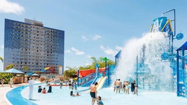 A water park with a large pool, water slides, and a tall water fountain. - Aqualand Resort (Salinópolis)