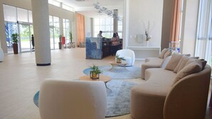 A spacious lobby with a reception desk, seating area, and large windows. - Aqualand Resort (Salinópolis)