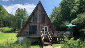A wooden cabin with a balcony and a wooden deck leading to the entrance. - Lakefront Aframe Cabin in Hardy on Kiwanie Lake with kayaks and private dock (Hardy)