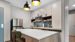 Una cocina moderna con una isla central, electrodomésticos de acero inoxidable y armarios de madera.