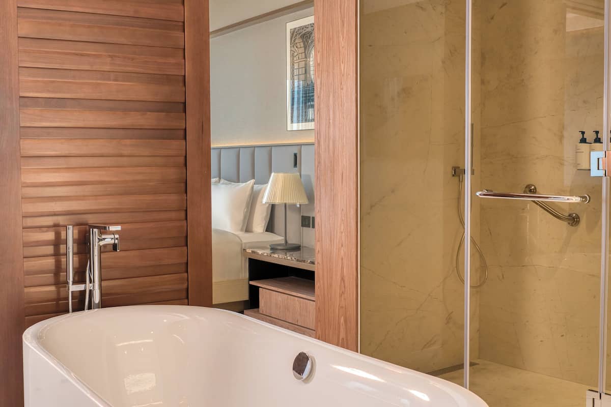 Un bagno moderno con una vasca freestanding, uno spazio doccia e un mobile lavabo con specchio.