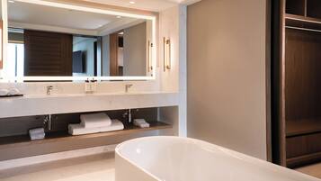Un baño moderno con un espejo grande, una bañera y estantes de madera.