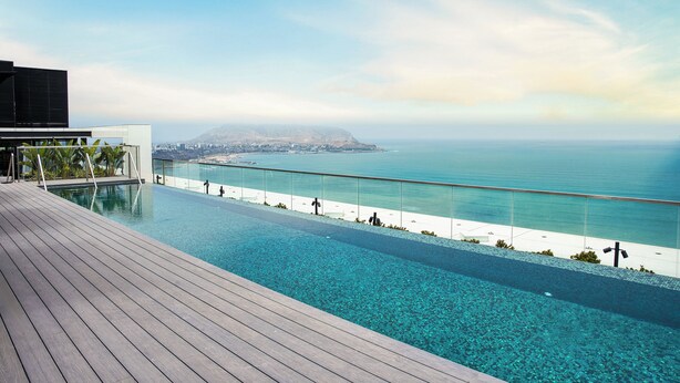 A modern infinity pool with a clear view of the ocean and a distant mountain range. - InterContinental Real Lima Miraflores by IHG (Lima)