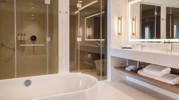 A modern bathroom with a freestanding bathtub, a glass-enclosed shower, and a vanity with a large mirror.