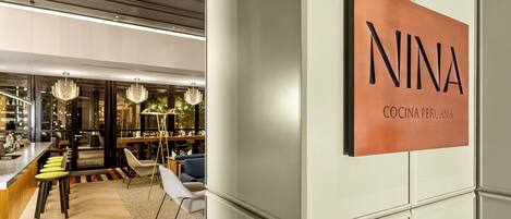 A modern interior with a bar area, seating, and a sign reading "NINA COCINA PERUANA".