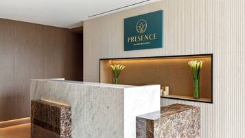 A reception desk with a marble top and a logo above it.