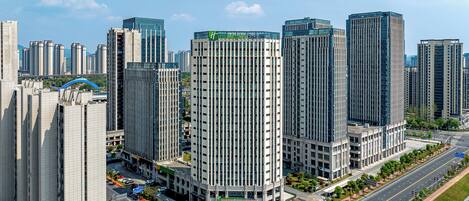 A high-rise hotel with a modern glass facade, surrounded by other tall buildings in a cityscape.