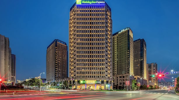 Een hoog Holiday Inn Express hotel met een modern ontwerp, met een opvallend bord bovenaan en meerdere verdiepingen met gelijke ramen.