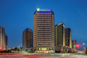 Een hoog Holiday Inn Express hotel met een modern ontwerp, met een opvallend bord bovenaan en meerdere verdiepingen met gelijke ramen.