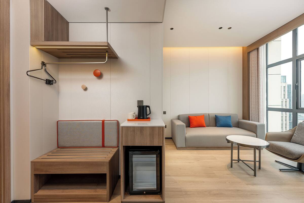 Un salon moderne avec un canapé, une table basse et un mini-réfrigérateur encastré.