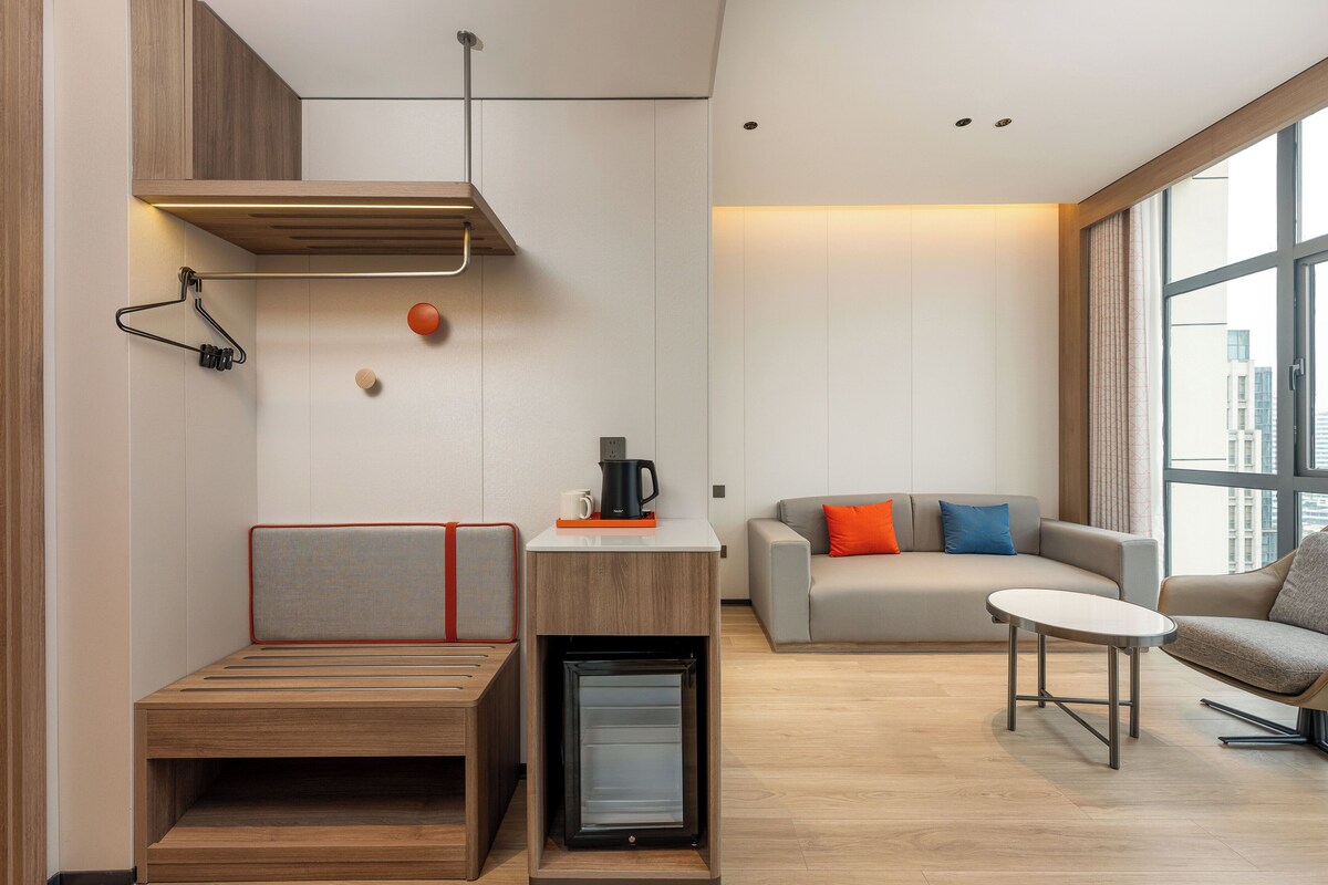 Un salon moderne avec un canapé, une table basse et un mini-réfrigérateur encastré.
