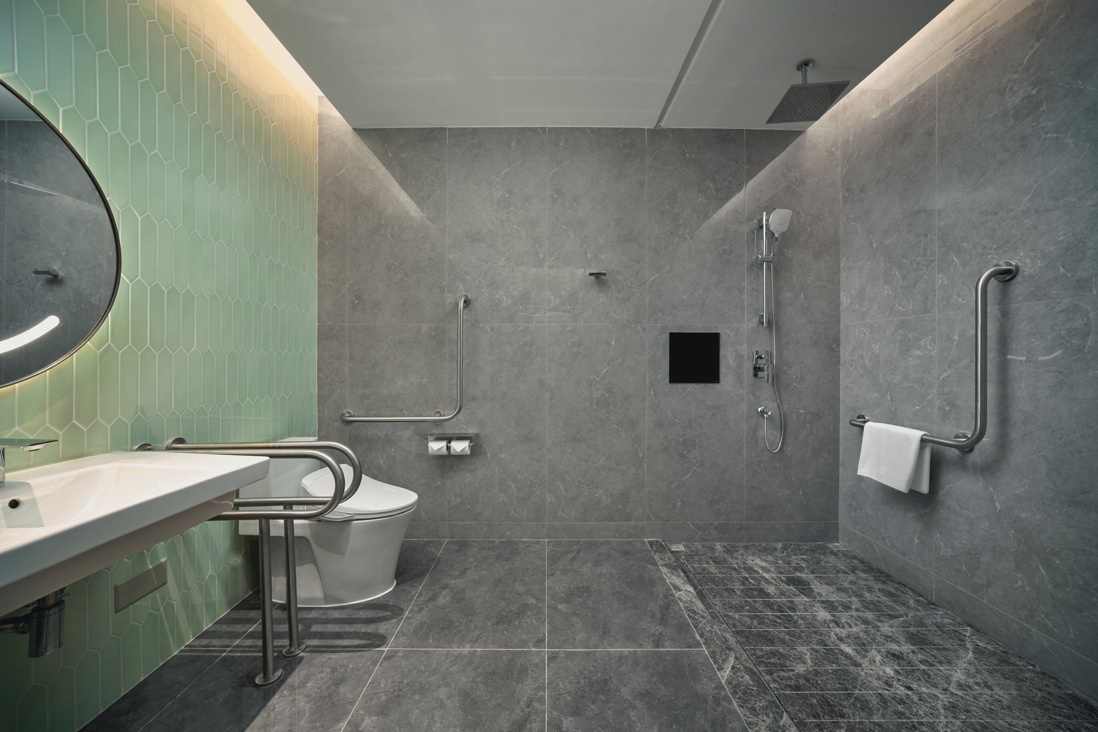 A modern bathroom with a sink, toilet, and shower.