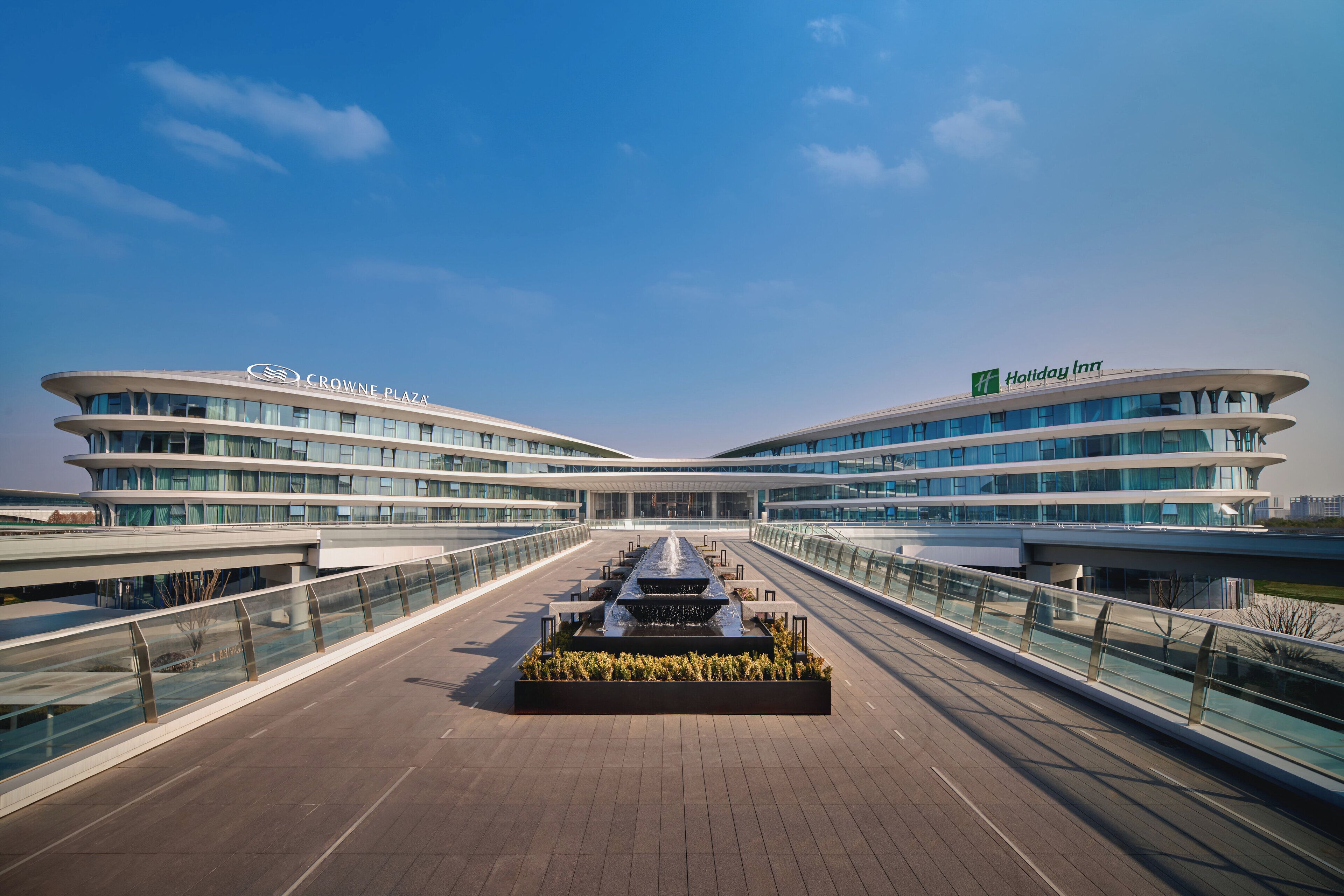 Ein modernes Hotel mit Innenhof, Glasgeländern und Flachdach-Architektur.