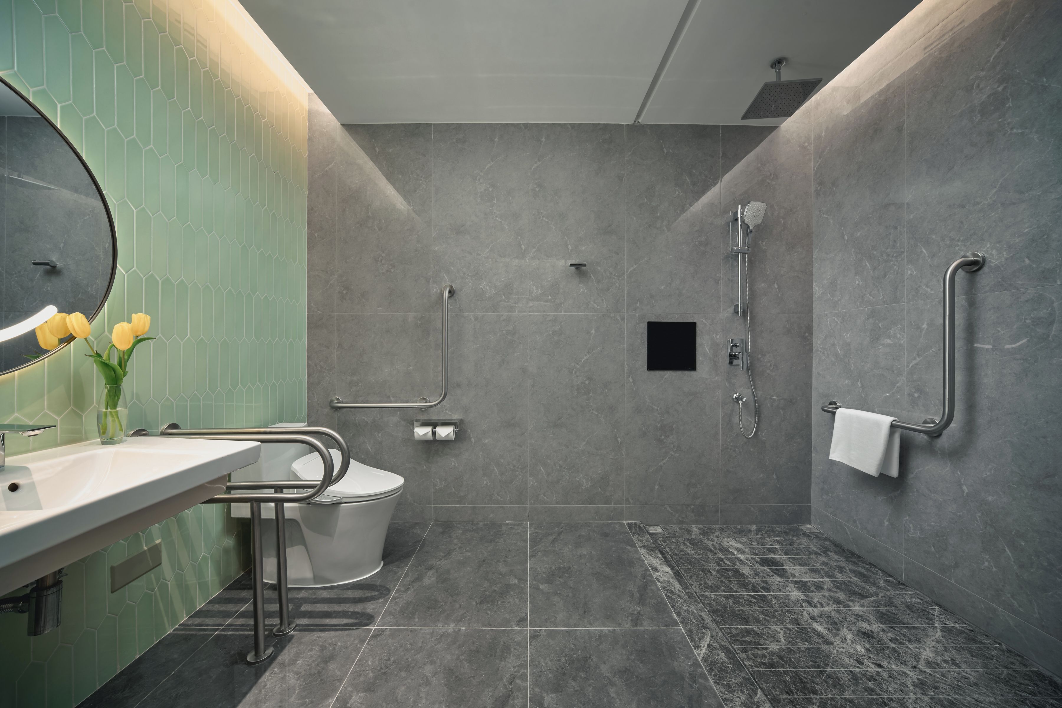 Un baño moderno con lavamanos, espejo, inodoro y zona de ducha.