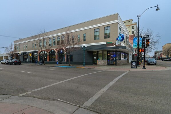 A building with a flat facade, large windows, and a storefront with a blue awning.