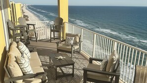 A balcony with outdoor furniture, a view of the beach, and a pier in the distance. - Luxury 23rd floor  Penthouse End Unit-Panoramic Ocean Front Views-Beach Service (Panama City Beach)