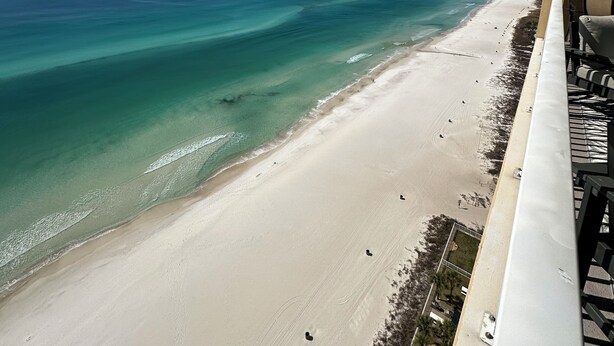 A beach view from a balcony with a clear sky. - Luxury 23rd floor  Penthouse End Unit-Panoramic Ocean Front Views-Beach Service (Panama City Beach)