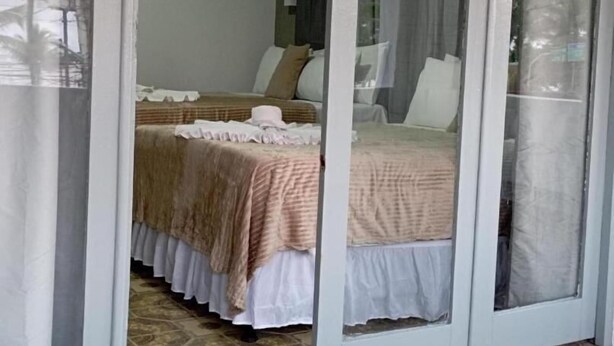 A bedroom with a bed, a painting on the wall, and an air conditioning unit. - Pousada Maceió é Massa Frente ao Mar (Maceió)