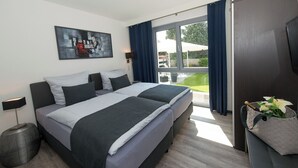 Ein modernes Hotelzimmer mit einem großen Bett, einem Flachbildfernseher und Blick ins Freie.