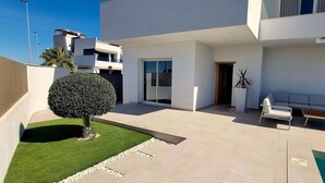 A modern outdoor living area with a pool, seating, and a well-maintained lawn. - Villa Escara with private pool (San Javier)