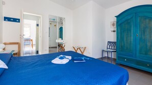 Ein Schlafzimmer mit einem großen Bett, einem Kleiderschrank und einem Schreibtisch mit Stuhl.