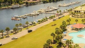A resort with a central swimming pool, a marina with boats, and a golf course.