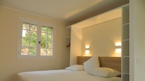 A bedroom with a bed, a window, and a built-in wardrobe. - Vacation apartment with large pool in the hills of the bay of St. Tropez (La Garde-Freinet)