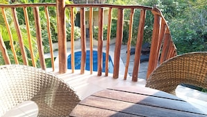 A wooden deck with a pool in the background, surrounded by lush greenery. - Wonderful space with 2 beds, overlooking the pool, downtown Tulum- Huanal H (Tulum)