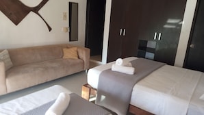 A hotel room with a bed, a sofa, and a wardrobe. - Wonderful space with 2 beds, overlooking the pool, downtown Tulum- Huanal H (Tulum)