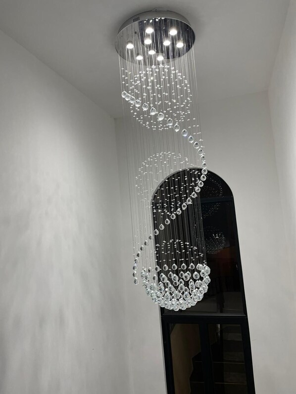 A modern chandelier with multiple tiers of hanging crystals.