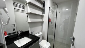 A modern bathroom with a black countertop sink, a toilet, and a glass-enclosed shower. - RN STUDIO - APTO 1009 (Maceio)