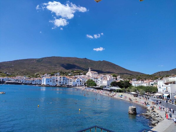 A coastal town with white buildings, a beach, and a mountain in the background. - STUNNING SEMI-DETACHED HOME IN SOTA EL CAMPANAR (Cadaqués)