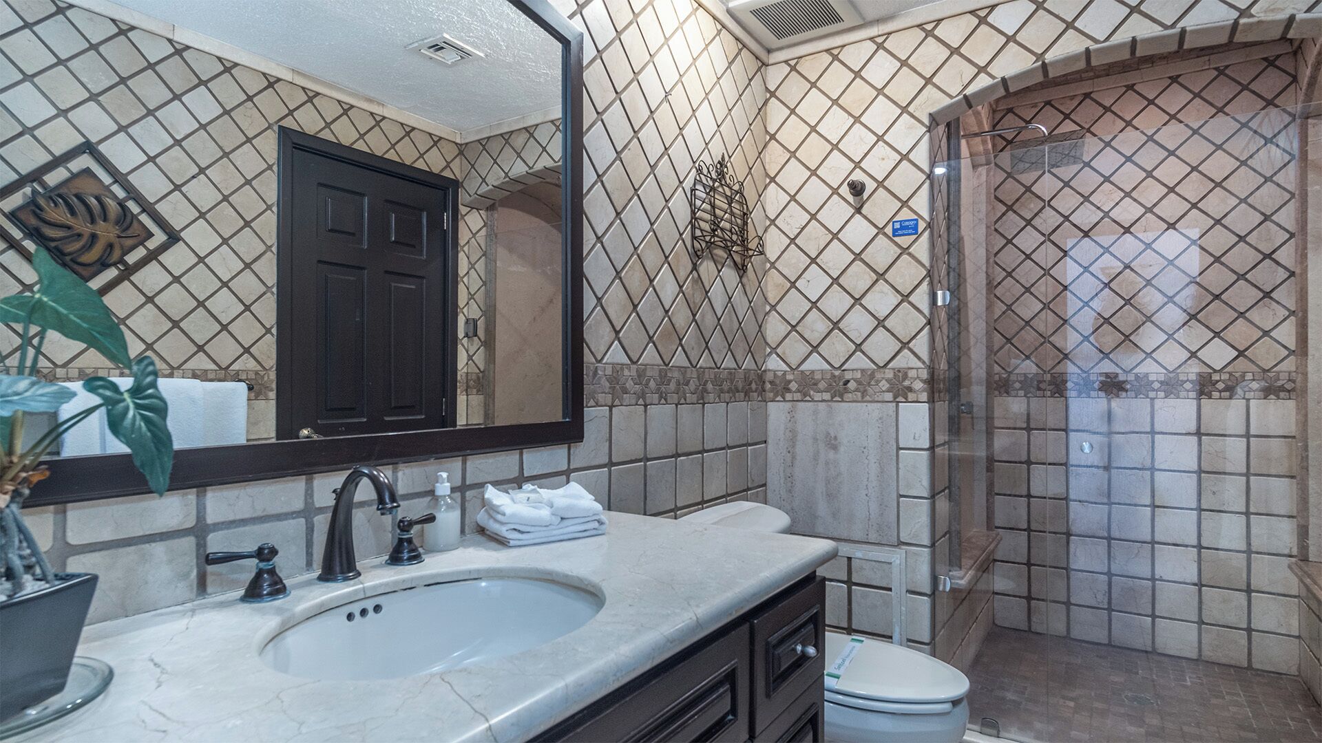 Un baño con lavamanos, espejo y ducha.