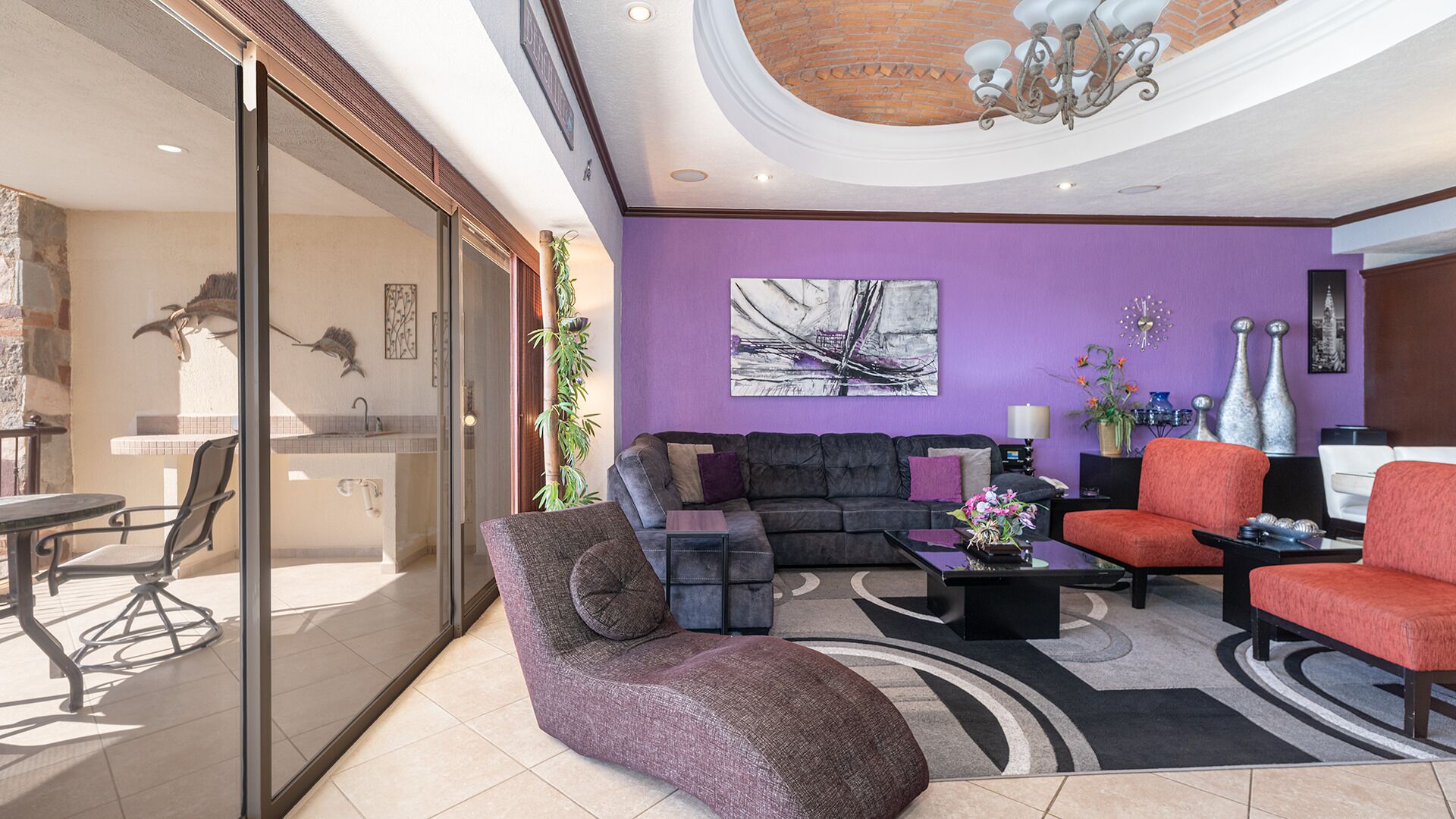 Un salon moderne avec un mur violet, une cheminée, un canapé et une table basse.
