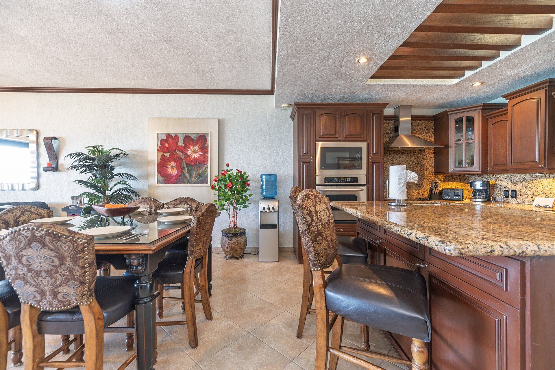 A spacious kitchen with granite countertops, wooden cabinets, and a large island.