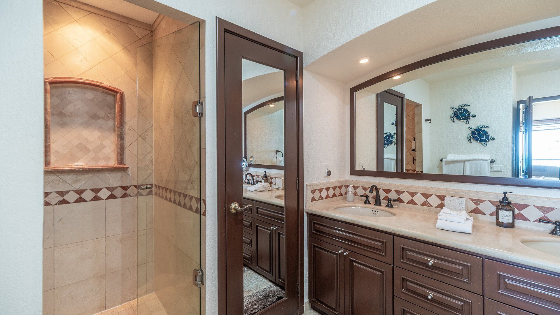 Une salle de bain avec une douche, un lavabo et un grand miroir.
