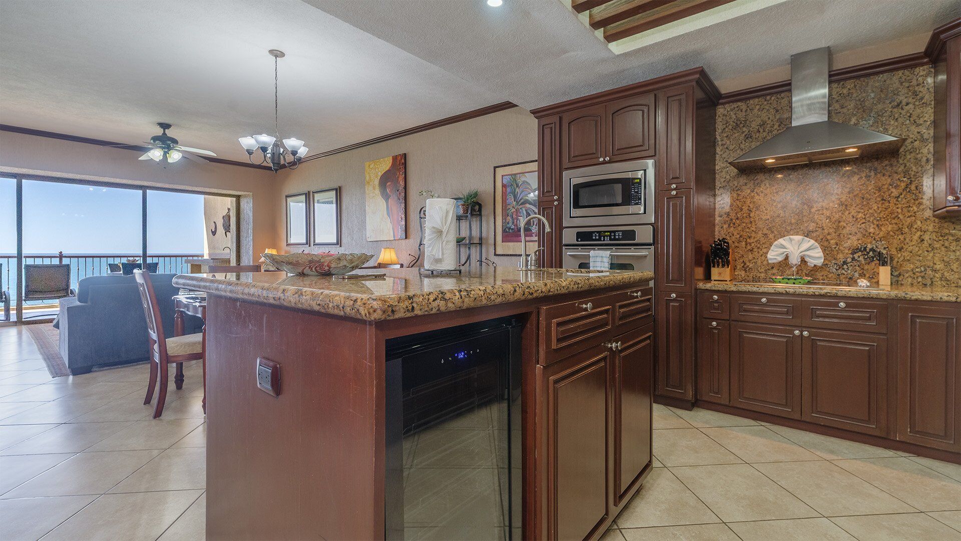 A modern kitchen with granite countertops, stainless steel appliances, and wooden cabinetry.