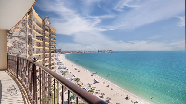Un balcon avec vue sur une plage et l’océan.
