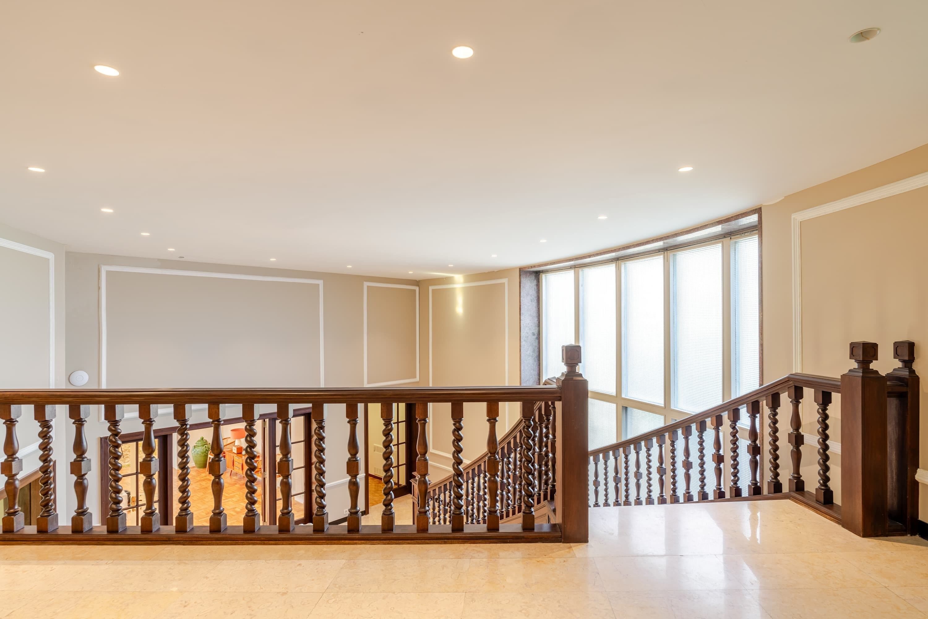 Ein geräumiges Interieur mit einer Holztreppe und einer hohen Decke.