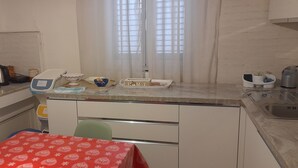 A compact kitchen with a microwave, kettle, and a small dining area with a table. - Ravenna Suite: apartment close to the center and major monuments! (Ravenna)