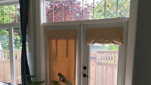 A room with a sliding glass door leading to a wooden deck, a potted plant, and a doormat. - Spruce Suite - Beach and Vineyard steps away! (Cobble Hill)