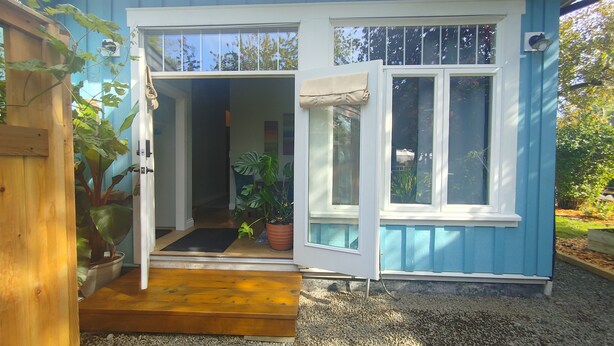 A house with a blue exterior, a wooden door, and a gravel driveway. - Spruce Suite - Beach and Vineyard steps away! (Cobble Hill)