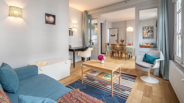 Una sala de estar moderna con un sofá, una mesa de centro y un comedor con sillas y una mesa.