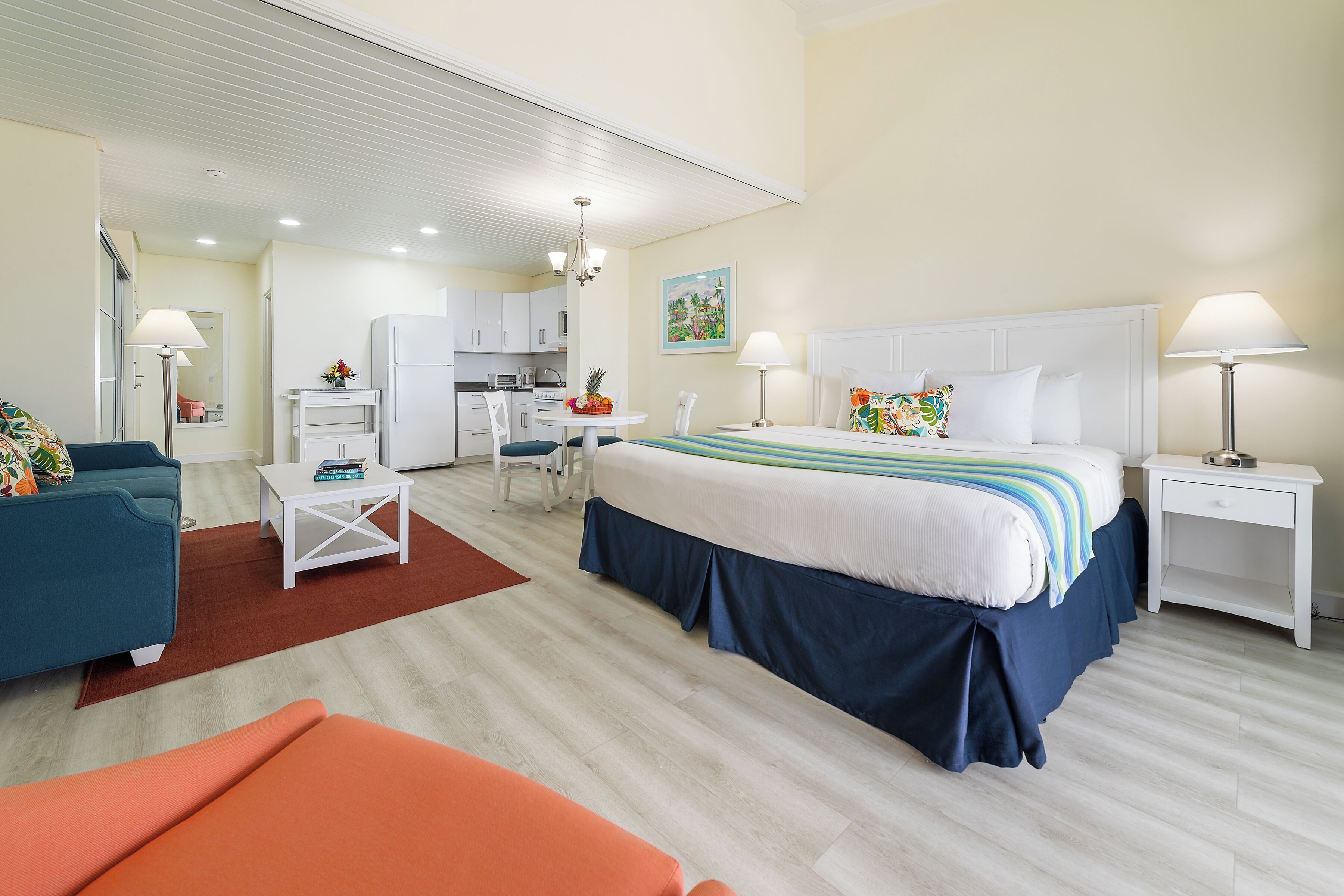 Una habitación de hotel con cama, sofá, escritorio y una zona de cocina.