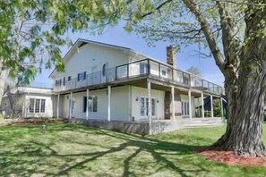 Stunning two-story residence with a spacious balcony and beautifully manicured lawn.