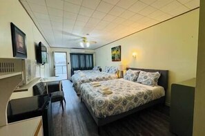 Relax in a stylish room with a large bed, two bedside tables, a desk, and a mounted television.
