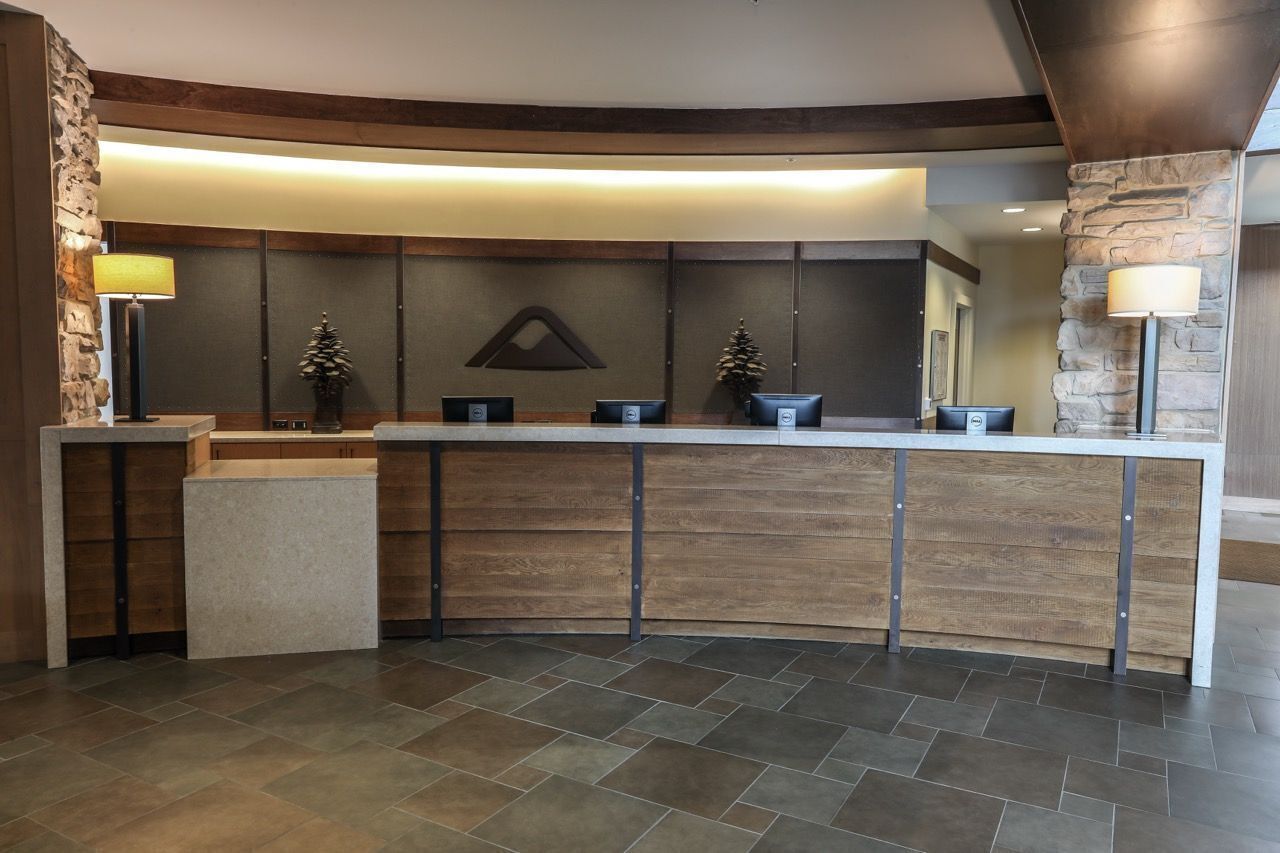 A reception area with a curved reception desk, stone accents, and a modern design.